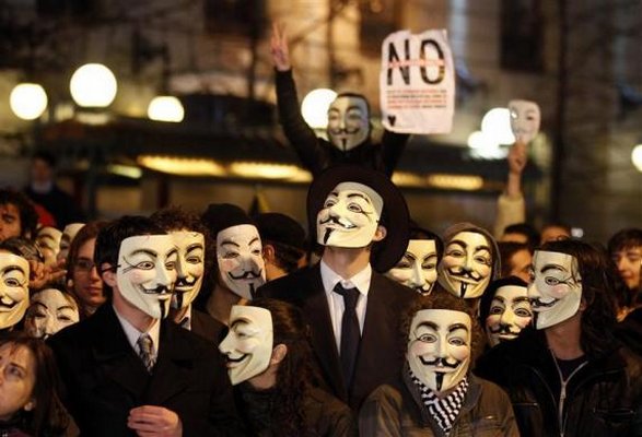 Guy Fawkes-maszkban tiltakozó spanyol fiatalok